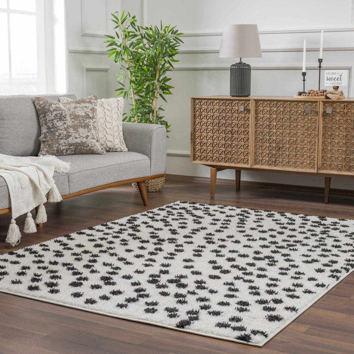 Cansu Black & White Dotted Area Rug, installed in a room