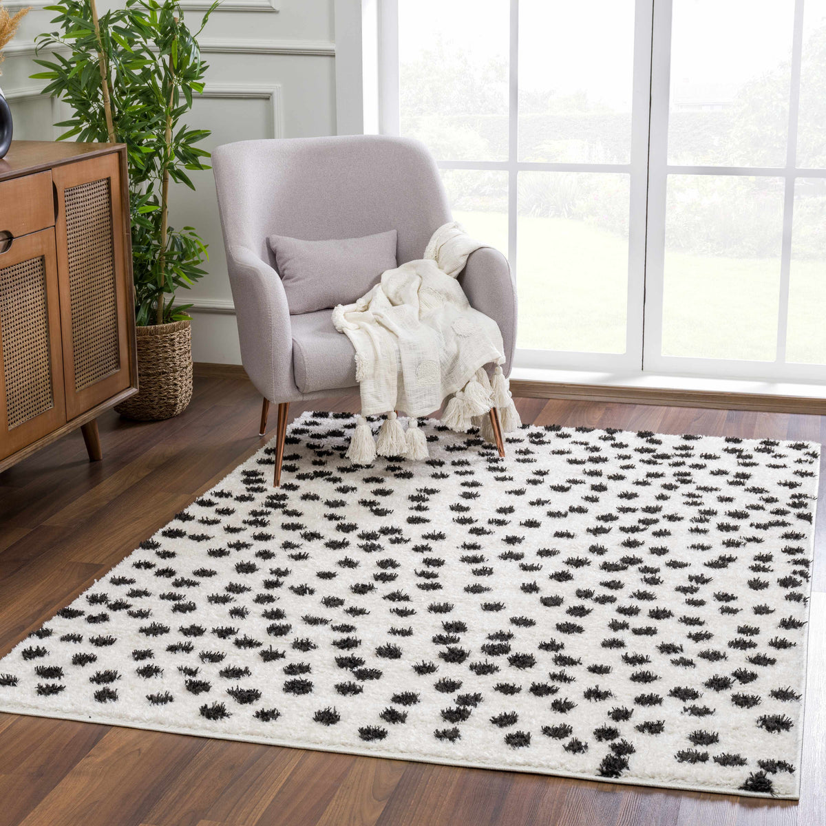 Cansu Black & White Dotted Area Rug, installed in a room