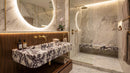 Luxurious bathroom with marble walls, a sink, and a shower.