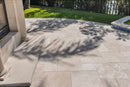 Outdoor patio with stone tiles and a view of grass and trees. Ivory Moderno Travertine Filled and Tumbled Pavers