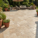 Outdoor patio with stone tiles, potted plants, and patio furniture.