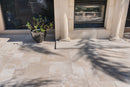 Paved patio area with a plant pot and architectural columns. Ivory Moderno Travertine Filled and Tumbled Pavers