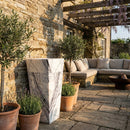 Outdoor patio with stone wall, potted plants, and a marble column. Natural Stone New York White Marble Pedestal Cone Shaped Sink Polished (W)16" (L)16" (H)36"