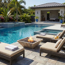 Outdoor pool area with lounge chairs, fire pit, and poolside house. Silver Travertine Natural Stone Fire Pit – 24" x 24" x 8"