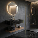 Modern bathroom with dark tiles, a round mirror, and a shower area.