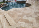 Beige stone patio with a pool in the background Aspendos Tumbled Travertine Pavers
