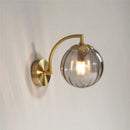 Blue and brass colored glass ball wall lamp for bedroom lighting by Decorbites
