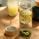 Minimalist glass water bottle with bamboo lid and kitchen time scale by Decorbites