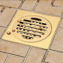 Gold square bathroom shower drain with interchangeable grates by Decorbites