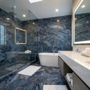Modern bathroom with blue marble walls and floor, white freestanding bathtub, and vanity area. Luna Sky Gray Marble Polished Wall and Floor Tile 12"x24"