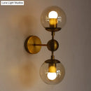 GobekUsa Post Modern Amber Glass Globe Wall Sconce with Brass Mount - 1/2 Light