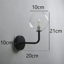Retro brass curved wall lamp with clear glass ball for bedroom by Decorbites