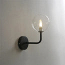 Retro brass curved wall lamp with clear glass ball for bedroom by Decorbites