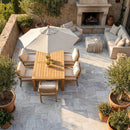 Outdoor patio with wooden table, chairs, and umbrella on a stone patio. Solto White Marble Leathered Pavers