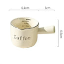 White ceramic espresso measuring cup and milk pitcher kitchen decor by Decorbites