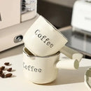 White ceramic espresso measuring cup and milk pitcher kitchen decor by Decorbites