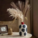 White ceramic polka dot vase with colorful graffiti lines living room by Decorbites