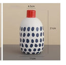 White ceramic polka dot vase with colorful graffiti lines living room by Decorbites