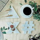 Carrara White genuine marble triangle round hastag x coasters 5x5 polished set of 4 SKU-MSBCRGEU5x5SP product shot  top view with a cup of coffee